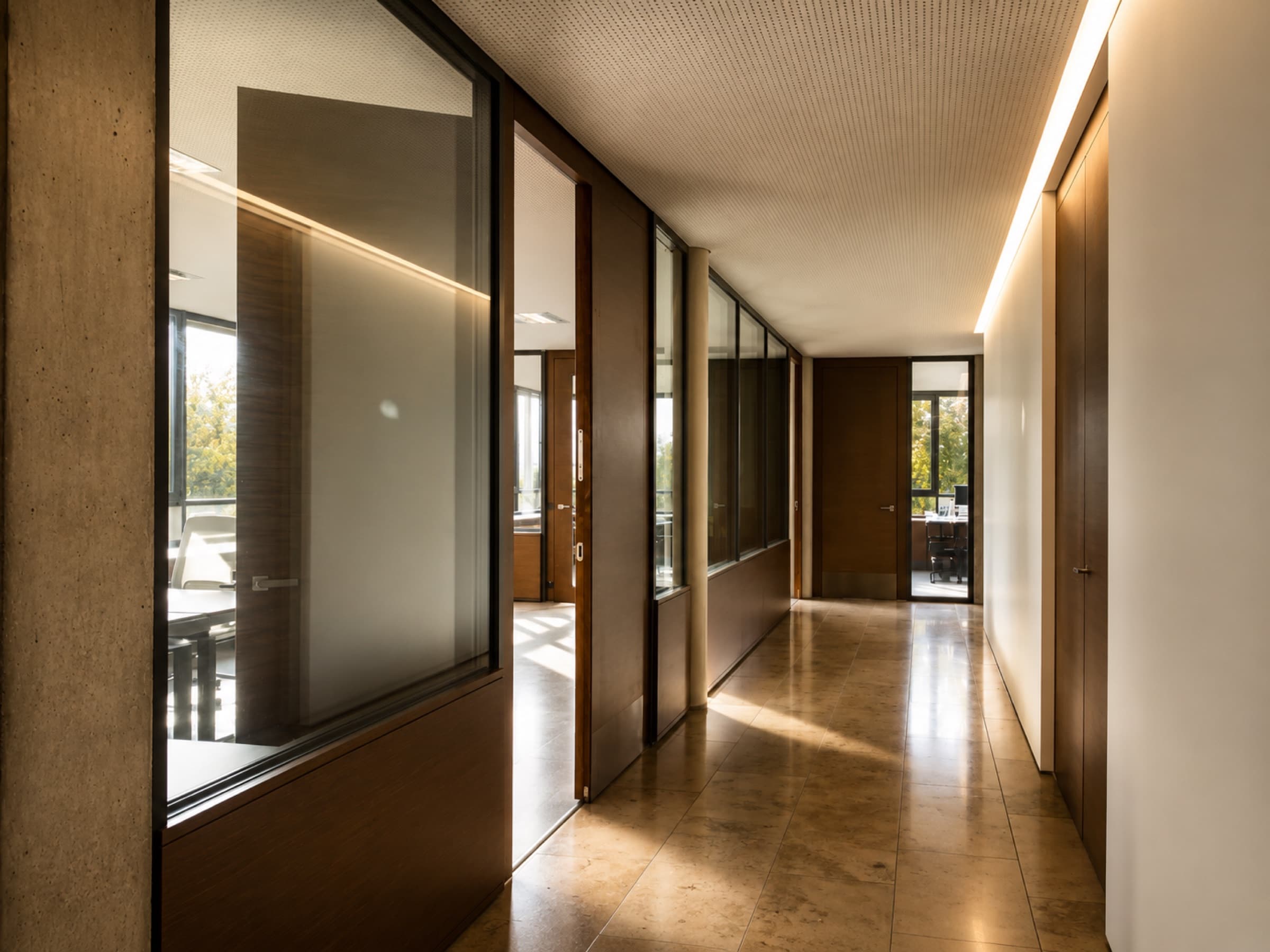 Vue intérieure d’un immeuble de bureaux avec sol en pierre naturelle et portes en bois